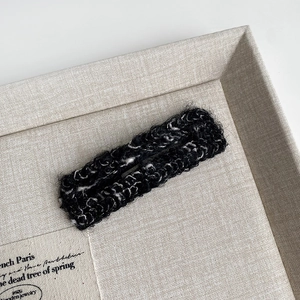 Detailed view of black and white knitted texture on a plush rectangle hair clip accessory