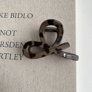 Vue détaillée d'une élégante pince à cheveux motif léopard sur un tissu en lin rustique