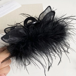 Detailed view of elegant black feather hair claw clip with a delicate mesh bow decoration
