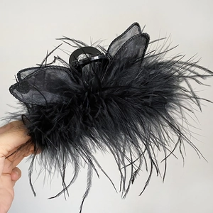 Detailed view of elegant black feather and mesh gauze hair claw clip with butterfly wing design