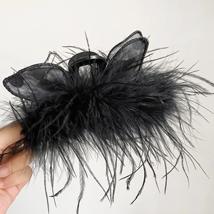 Detail shot of a large black feather butterfly hair claw clip with gothic velvet texture