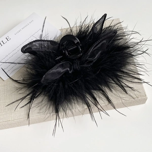 Detail of large black feather shark hair claw clip with satin bow and mesh for women