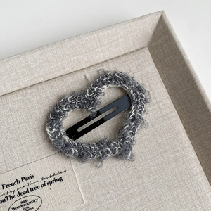 Close-up of heart-shaped BB clip featuring grey and white tweed woven plush texture