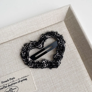 Detailed view of heart-shaped plush knitted hair clip with integrated BB clip on display