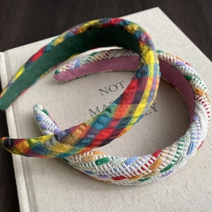 Detail of colorful woven braided headbands and plaid fabric hair hoops on a book