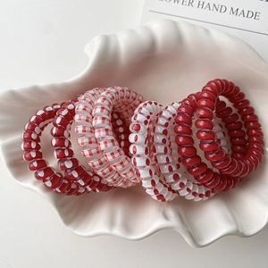 Lot de 7 élastiques spirale à pois rouges et blancs présentés dans un plateau coquillage