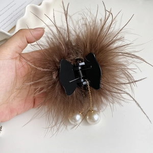 Détail d'une grande pince à cheveux en plumes avec glands en perles et plumes brunes