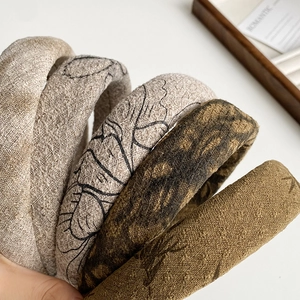 Detailed macro view of four vintage ink print sponge headbands with fabric texture