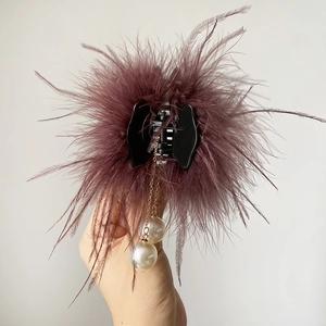 Gros plan détaillé sur pince à cheveux à plumes violettes avec pendentifs perles