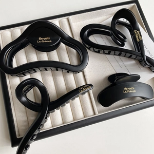 Set of four matte black cloud hair claws with gold lettering for elegant hairstyling
