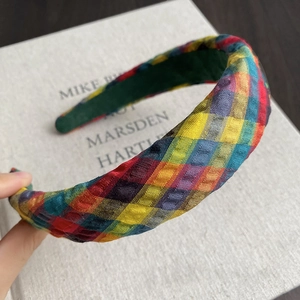 Detail of colorful woven checkerboard headband showing textured fabric and volume