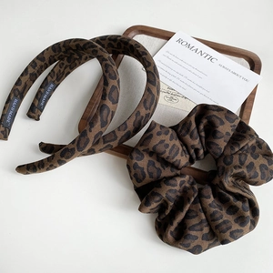 Detail view of handmade leopard print fabric headbands and scrunchies set on a tray