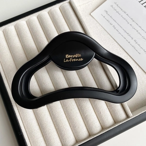 Detail view of large matte black hair claw clip with golden Barrette La France lettering