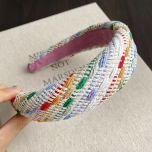 Detailed view of colorful woven texture on wide headband with soft purple lining