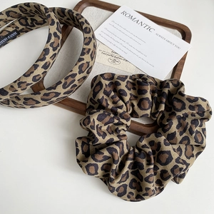 Detail shot of vintage leopard print headband and large hair scrunchie set on wood