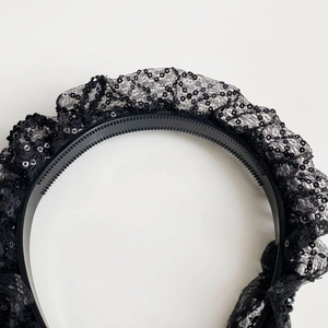 Détail de serre-tête en dentelle noire avec sequins brillants sur une monture antidérapante