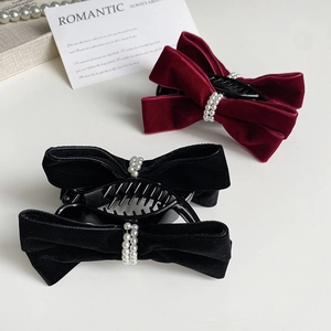 Detailed view of velvet bow hair clips with white pearls in black and wine red colors