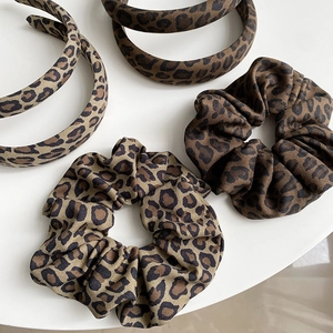 Detailed set of leopard print headbands and scrunchies in brown fabric textures