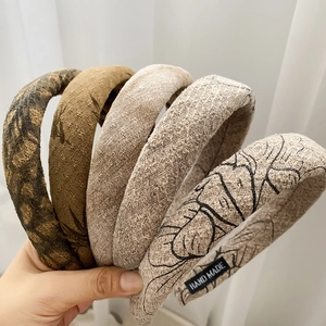 Detailed close-up showing texture of five retro ink print sponge headbands in various patterns