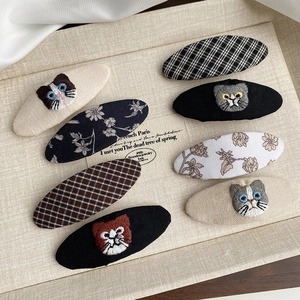 Détail d'un lot de sept barrettes BB en tissu avec broderies de chats et motifs floraux