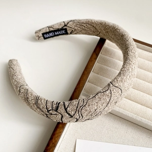 Detail of hand made sponge headband with vintage ink print and fabric texture