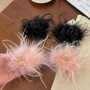 Detailed view of elegant large feather hair claws in black and pink with tulle bows