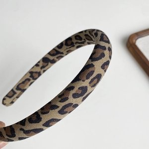 Detailed macro view of the vintage leopard print fabric texture on a wide headband