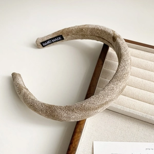 Detail of khaki linen fabric headband featuring a hand-made woven label on the side