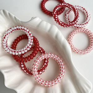 Gros plan sur les élastiques spirale à pois rouges et blancs dans un plat