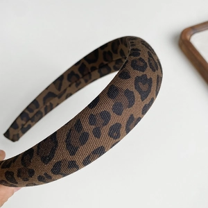 Close-up detail of leopard print fabric headband featuring classic brown and black patterns