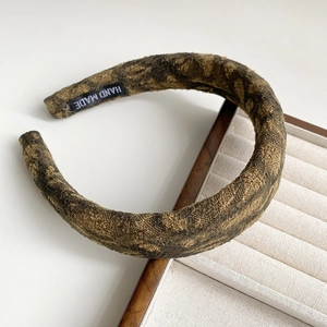 Detail of vintage ink print sponge headband showing thick brocade texture and handmade label