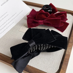 Close-up of elegant velvet double bow hair claws in burgundy red and classic black