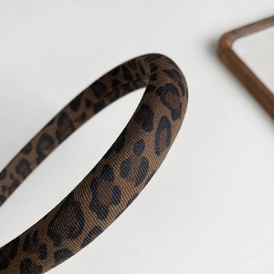 Close-up of leopard print fabric headband featuring premium twill texture and rich patterns