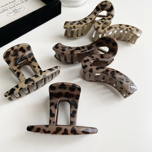Detail of vintage leopard print hair claws in rectangle and wave shapes on gray background