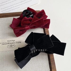 Detail of red and black velvet double bow hair claws in an elegant French vintage style