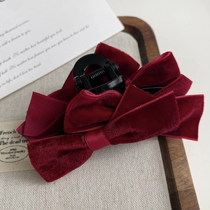 Detail view of burgundy velvet double bow hair claw with high gloss black finish