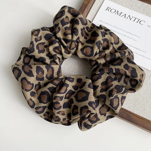 Detail of leopard print fabric scrunchie with rich folds and vintage texture