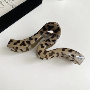 Detail view of leopard print hair claw clip with S-shaped curve and metal spring
