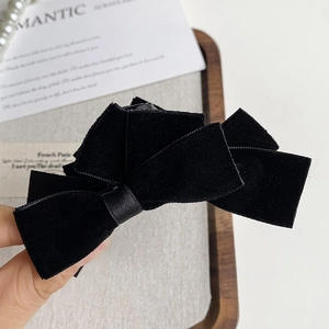 Detailed close-up of a premium black velvet double bow hair claw with soft texture