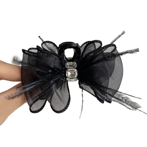 Elegant black bow hair claw with delicate feathers and sparkling rhinestones for women