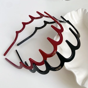Dettaglio di cerchietti ondulati in resina nero e bordeaux con design antiscivolo