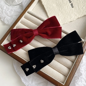 Detail of velvet bow hair clips with heart rhinestones in a luxury gift tray