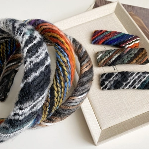 Close-up of handmade woven hairbands and clips in colorful knitted wool texture