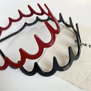 Dettaglio di cerchietti in resina rossi e neri con logo Barrette La France dorato