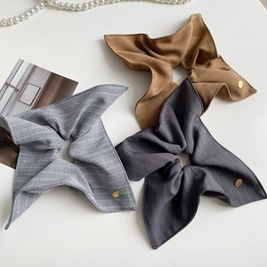 Trois chouchous en lin texturé bleu, marron et gris avec des accents dorés élégants