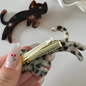 Detail of cute cat shaped acetate hair clips in tortoise and marble patterns
