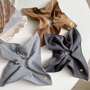 Détail de chouchous en tissu haut de gamme à rayures café et gris avec breloques dorées