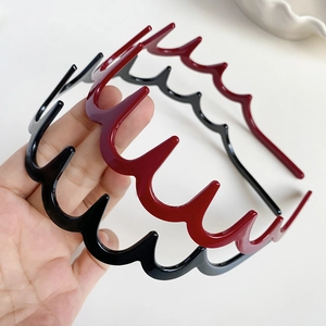 Dettaglio di cerchietti ondulati in resina con denti antiscivolo, nero e rosso scuro