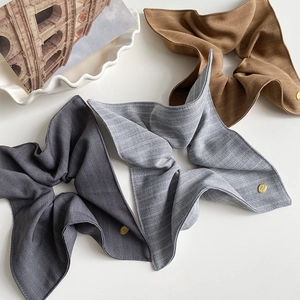 Trois chouchous élégants en tissu gris, rayé et marron avec petit logo doré