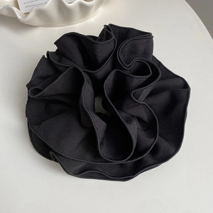 Détail d'un chouchou noir à plusieurs couches avec texture douce à côtes